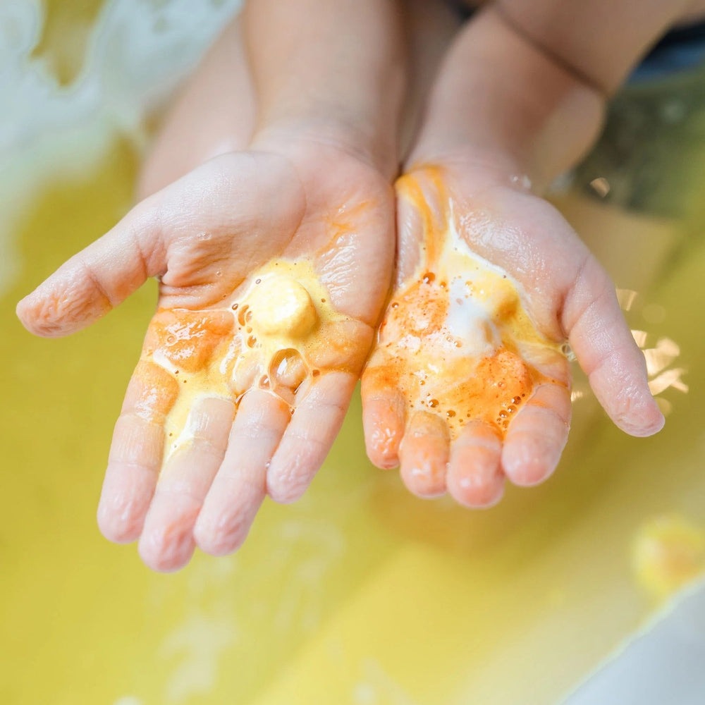 Loot Toy Co Funky Fish Food Mellow Yellow bath foam on hands with orange-yellow bubbles