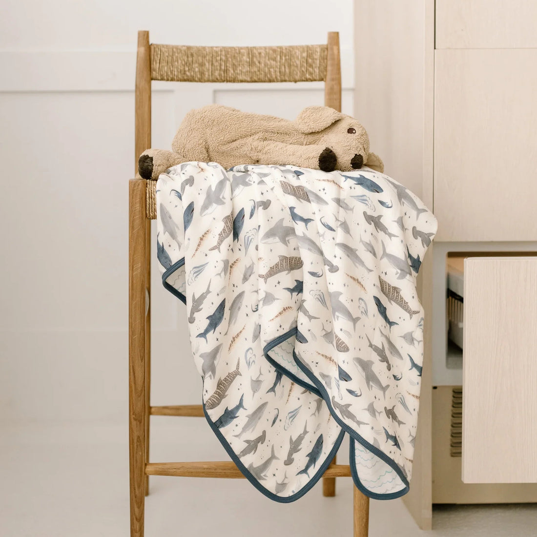 Loulou Lollipop Baby Muslin Quilt in Tanboocel® Bamboo Viscose - Smiley Sharks — quilt blanket shown in a nursery setting.