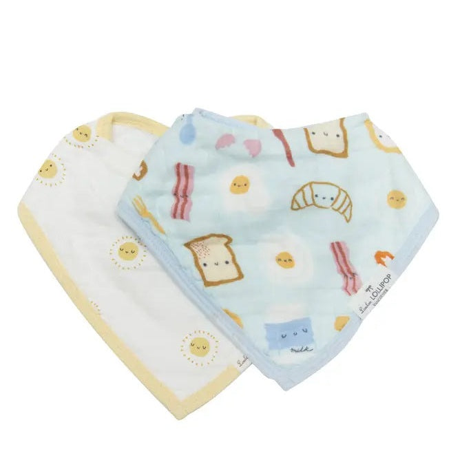Loulou Lollipop Bandana Bib Set; two pastel bibs in blue and cream overlapping to show sun and food prints.