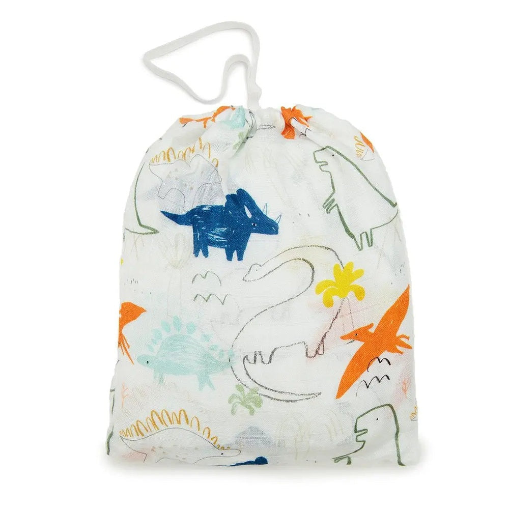 LOULOU LOLLIPOP fitted crib sheet in white with colorful dinosaur print, folded inside a white drawstring bag.