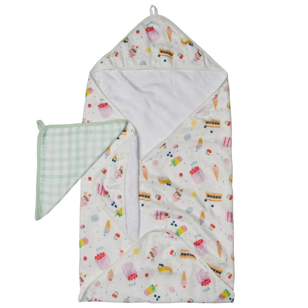 Loulou Lollipop Hooded Towel Set: white hooded towel with colorful dessert print and mint gingham washcloth folded at the side.