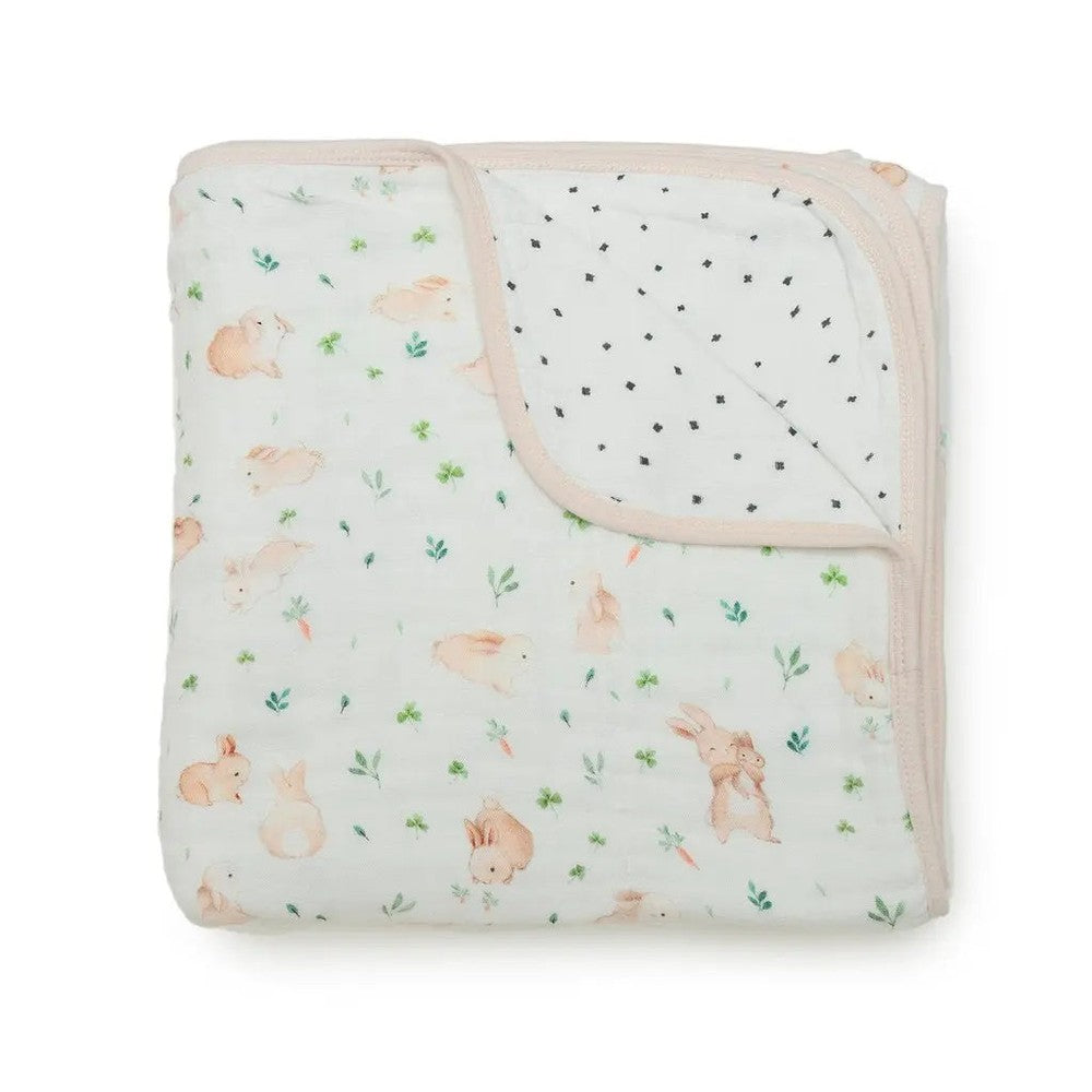 Loulou Lollipop Muslin Quilt Blanket folded, pastel rabbit print with pink trim, breathable swaddling blanket.
