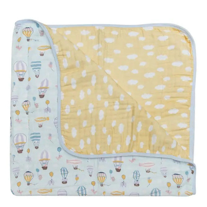 Loulou Lollipop Muslin Quilt Blanket, pastel blue balloon print with yellow inner side, laid flat to show dual-sided design.