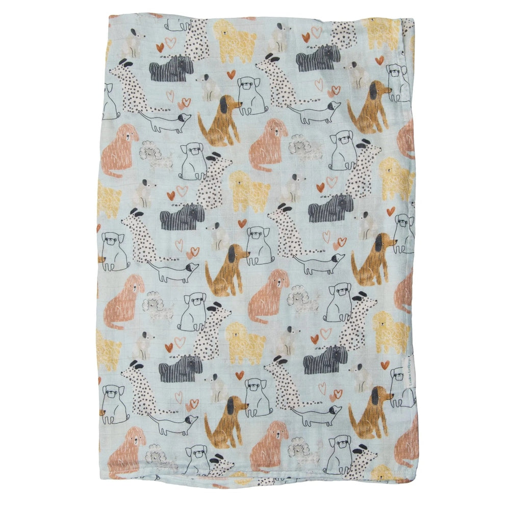 Loulou Lollipop Muslin Swaddle blanket, pastel dog print on light blue, laid flat to show soft breathable fabric.