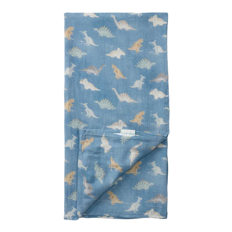 Loulou Lollipop Muslin Swaddle blue dinosaur print, laid flat with corner folded to show breathable, cozy fabric