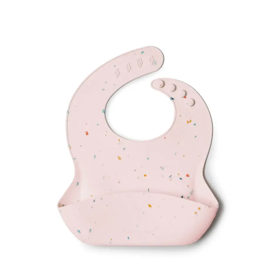 Loulou Lollipop Silicone Bib pink speckled with confetti, featuring a front catch-pocket and adjustable neck snaps for mealtime.