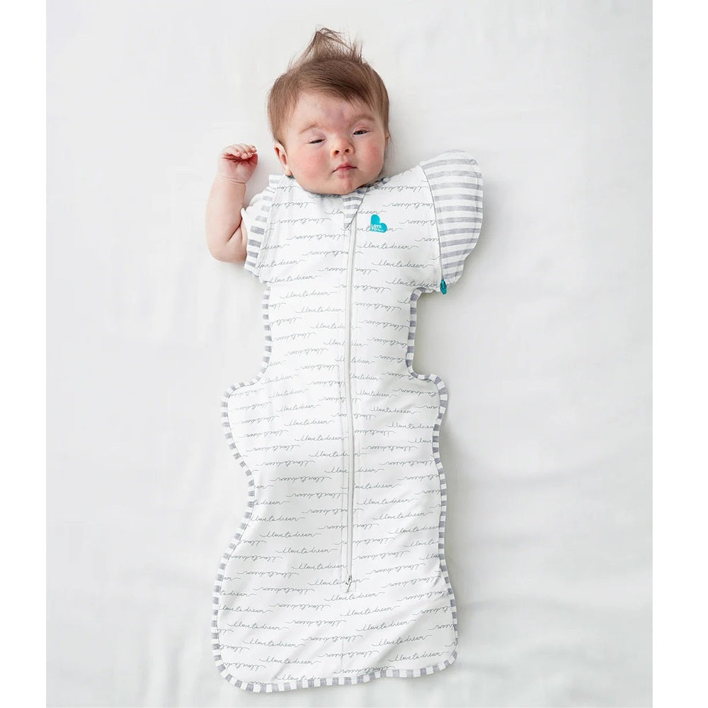 Love To Dream Swaddle Up Transition Bag Original Cotton 1.0 Tog White Dreamer, baby sleeping with arms up in striped sleeves.