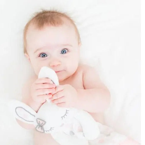 Lulujo Lovely Muslin Cotton baby blanket in white, baby cuddling a soft plush bunny.