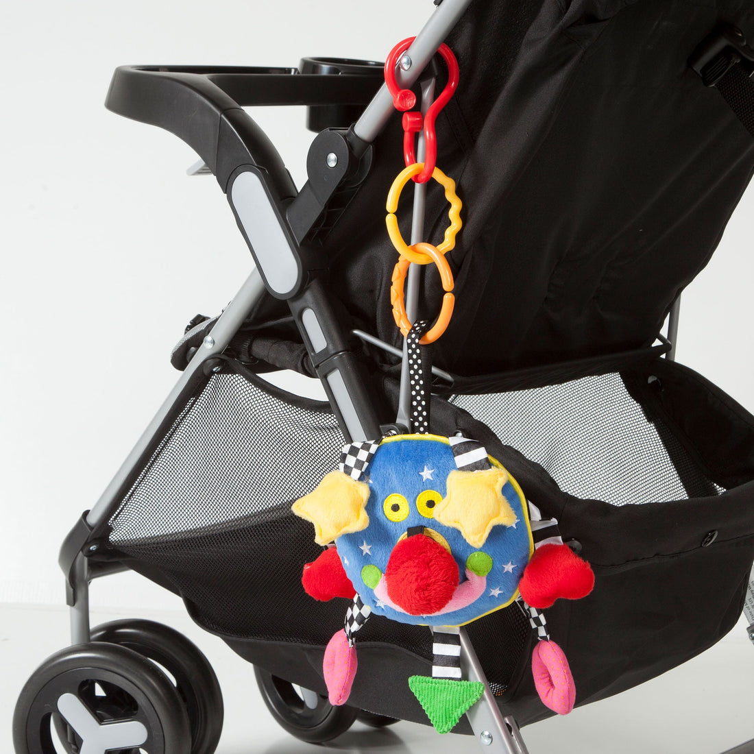 Manhattan Toy Baby Whoozit 6" Stroller & Travel Activity Toy - hanging from a stroller with linking rings