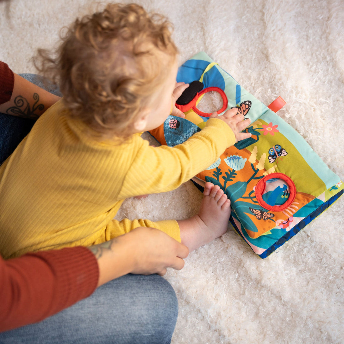 Manhattan Toy Bugging Through Sensory Book - toddler moving the bug through the open pages
