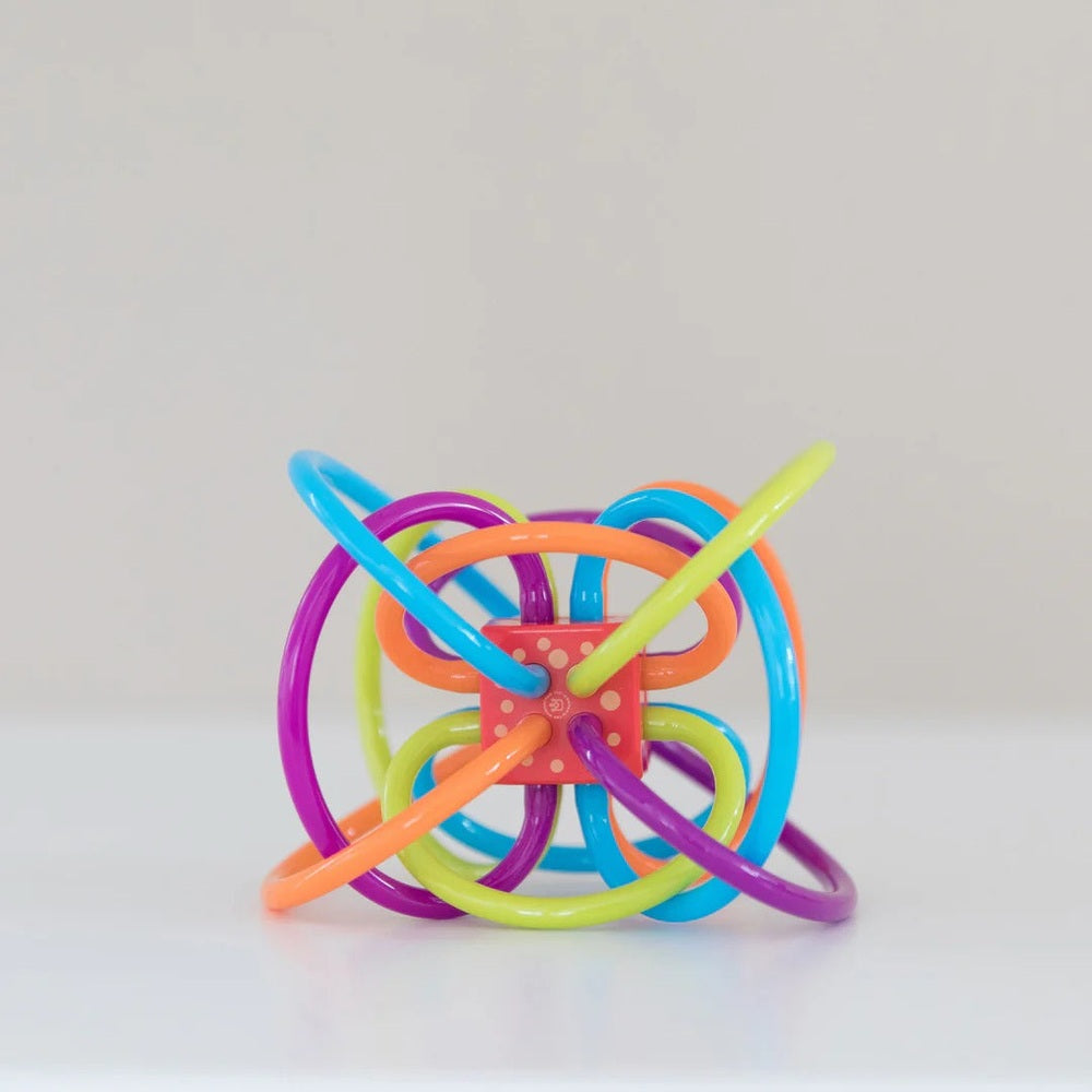 Manhattan Toy Winkel Rattle Sensory Teether Toy; bright colorful loops weave around a red center for baby teething.