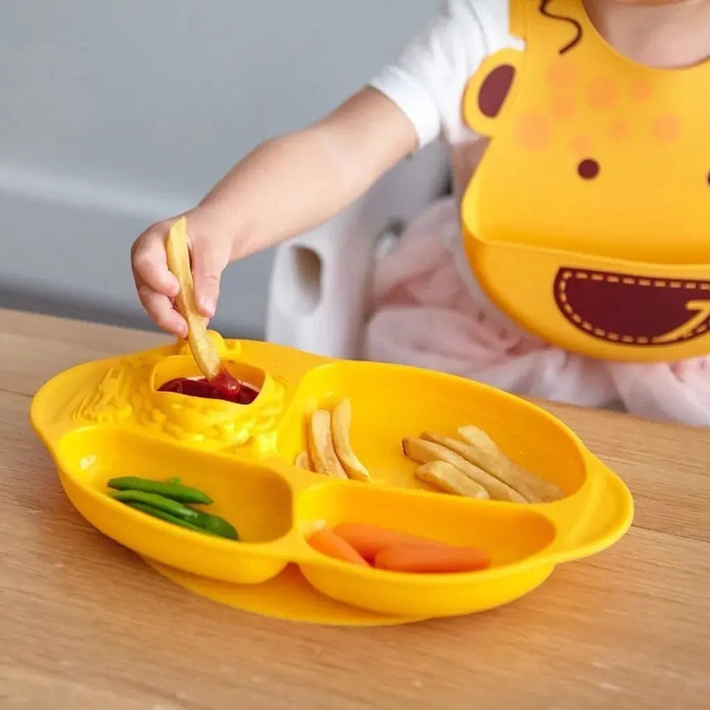 Marcus & Marcus Yummy Dips suction divided plate in bright yellow; child dips fries into the center sauce compartment.