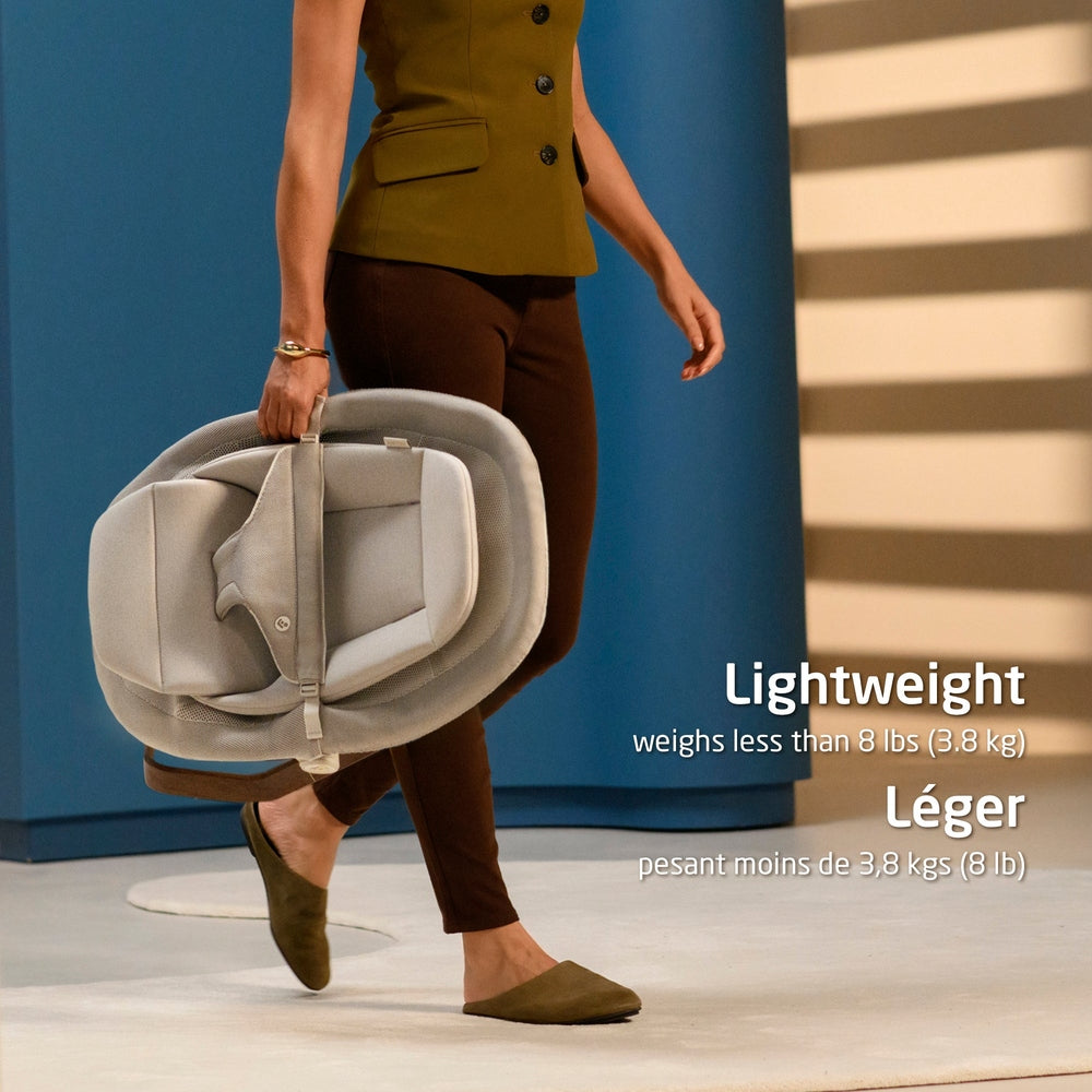 Light gray folded baby bouncer being carried indoors