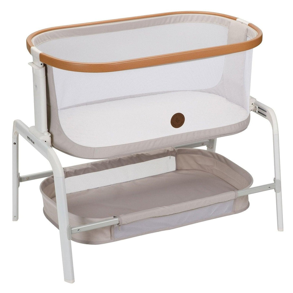 Maxi-Cosi Iora Bedside Bassinet with white mesh sides and beige trim atop a sturdy white frame.