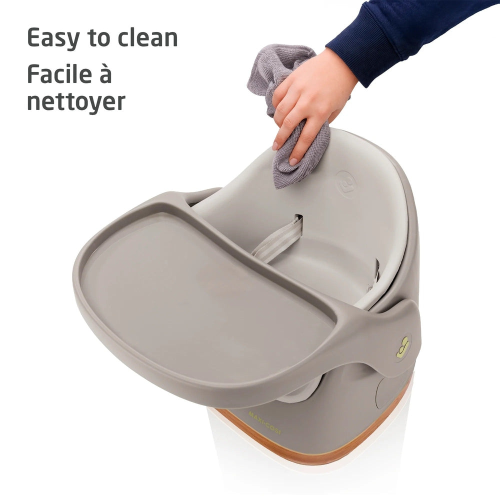 Baby high chair being cleaned with a cloth on a white background
