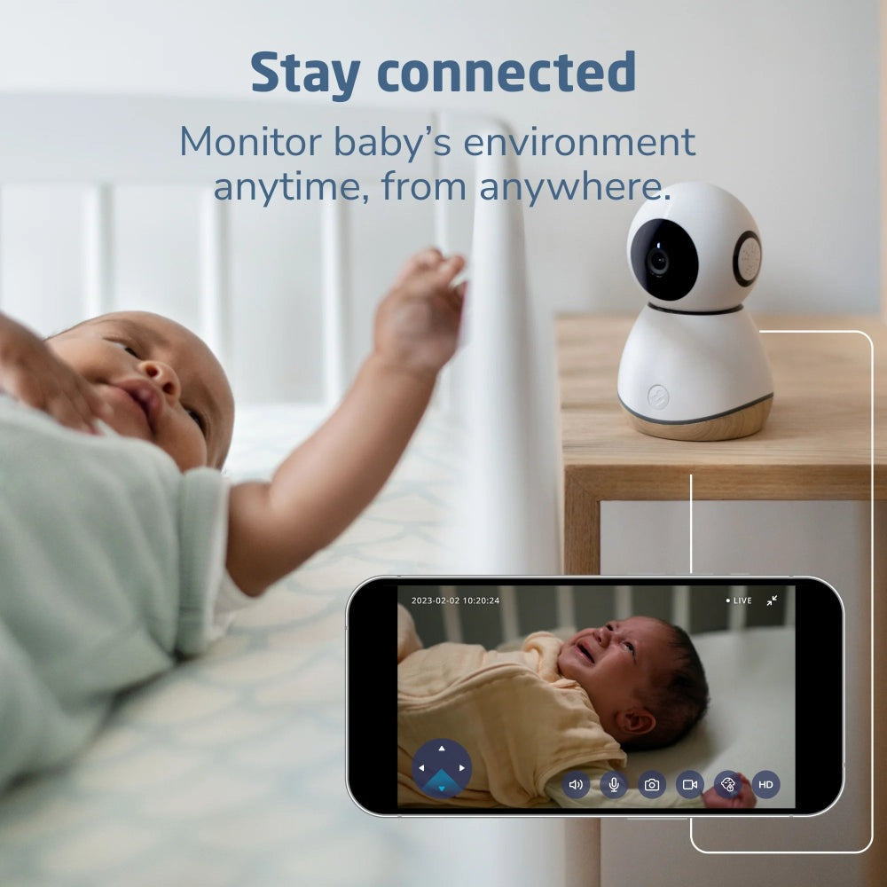 Maxi-Cosi See Pro 360 Baby Monitor with white camera and wood base on nightstand; baby in crib