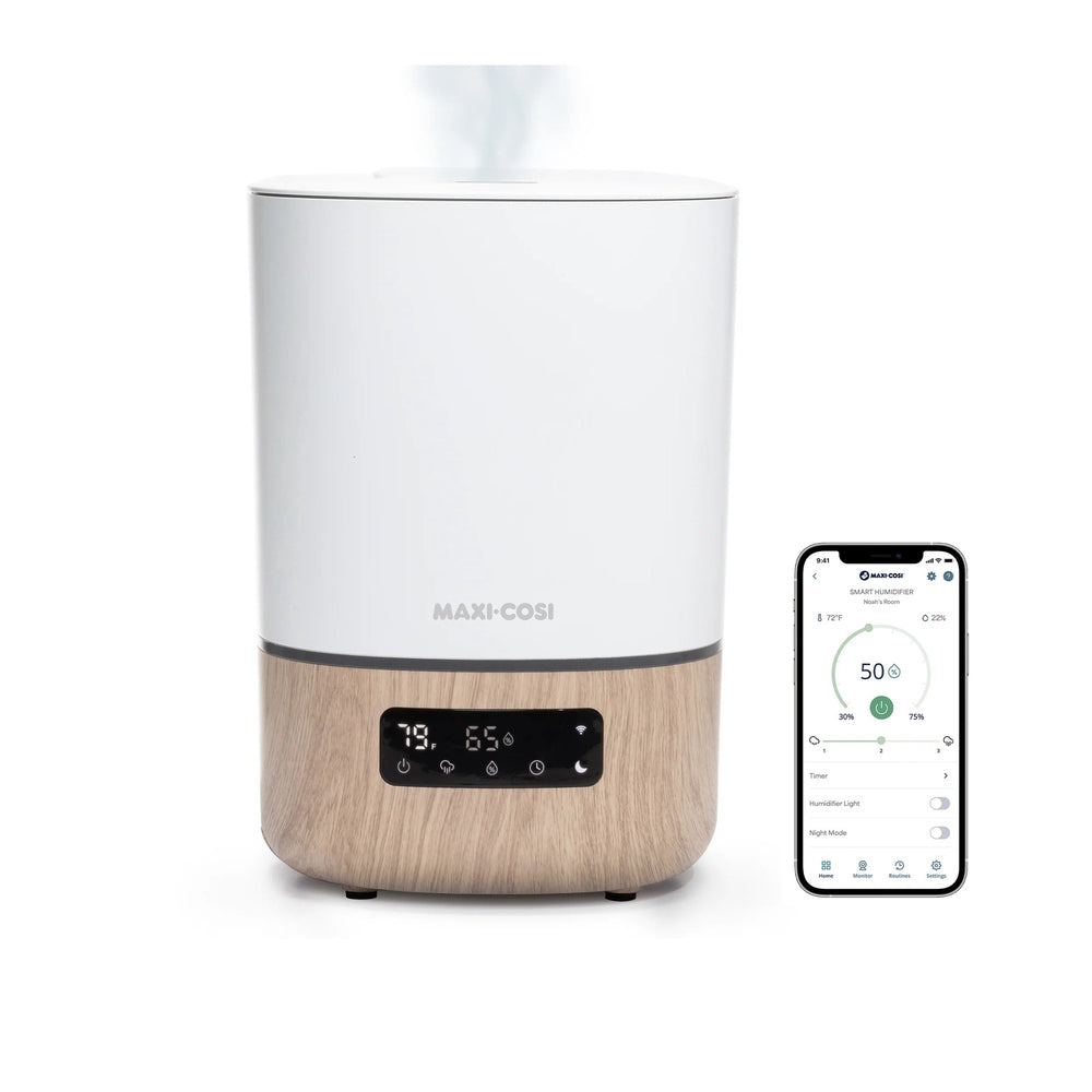 MAXI COSI Smart Humidifier with white top and wood base; digital display shows settings while steam rises, smartphone app beside.