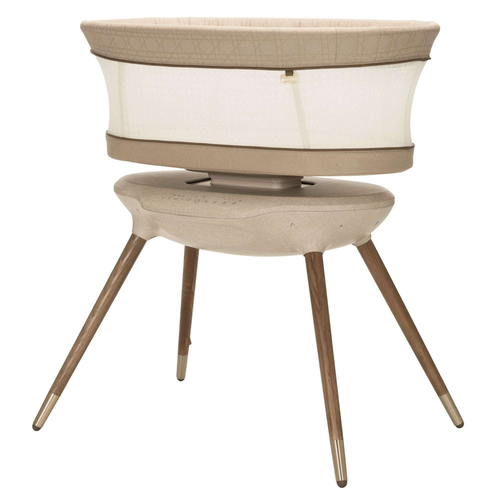 MAXI-COSI Starling Smart Bassinet on beige fabric with wooden tripod legs