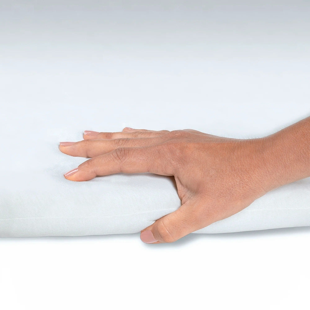 MAXI COSI Swift/Calao Bassinet Sheets Set of 2, white fitted sheets shown being smoothed over a bassinet mattress.