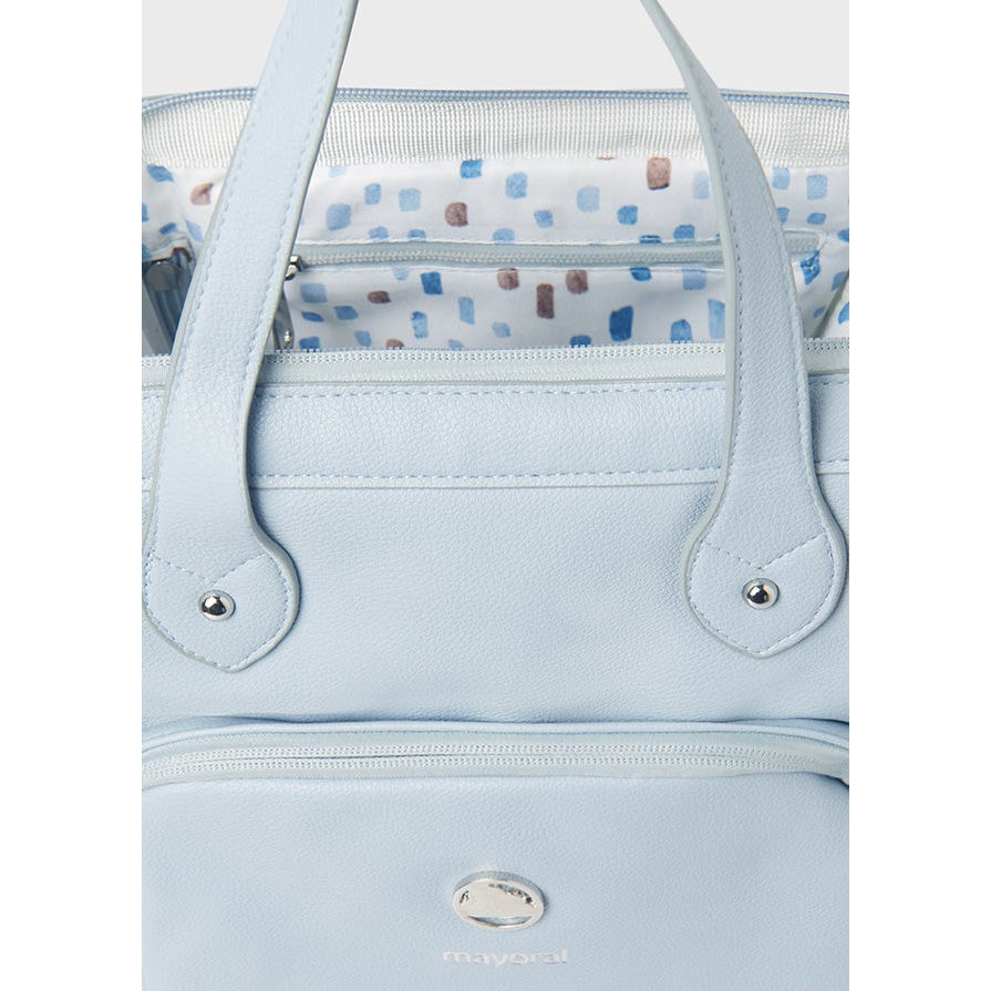 Light blue handbag with a patterned interior lining on a light gray background