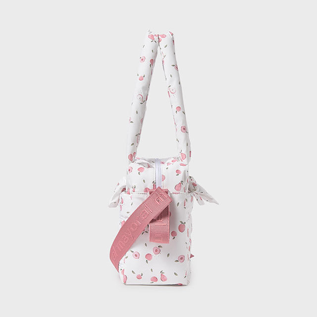 Small white bag with pink floral pattern and strap on a light gray background