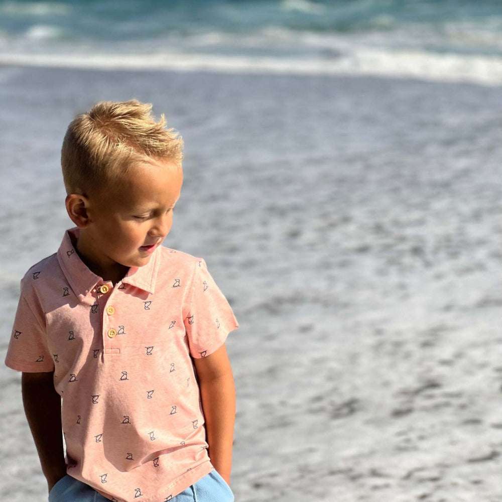 Me & Henry Polreath Henry Print Polo Shirt peach, short-sleeve polo with small print worn by a boy at the beach