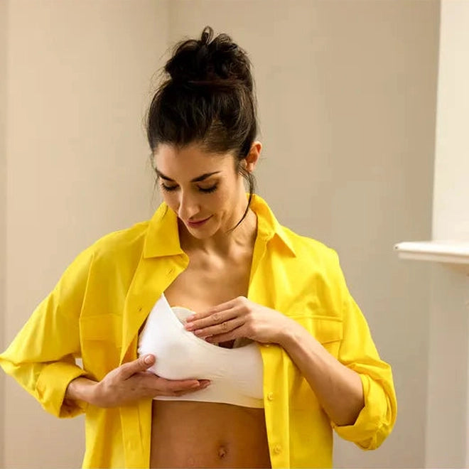Medela Magic InBra Wearable Breast Pump worn under a white bra, demonstrating a hands-free pumping solution.