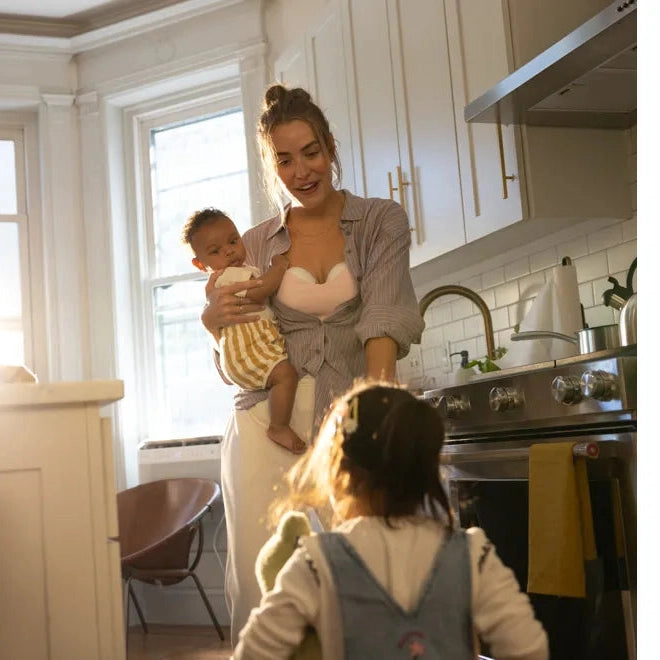Medela Motion Inbra Double Electric Breast Pump in a cozy kitchen moment with mom and two children