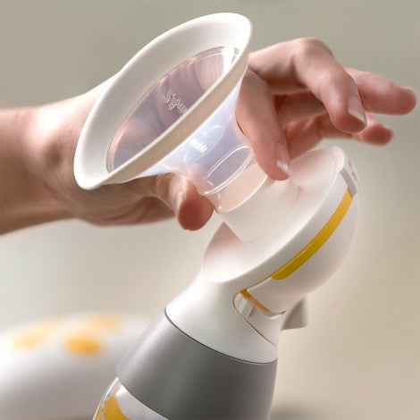 Medela Solo electric breast pump with clear shield and bottle, white and gray with yellow accents