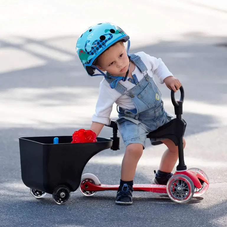 Micro Balance Bike Trailer: toddler in blue helmet rides a red scooter attached to a black cargo trailer.