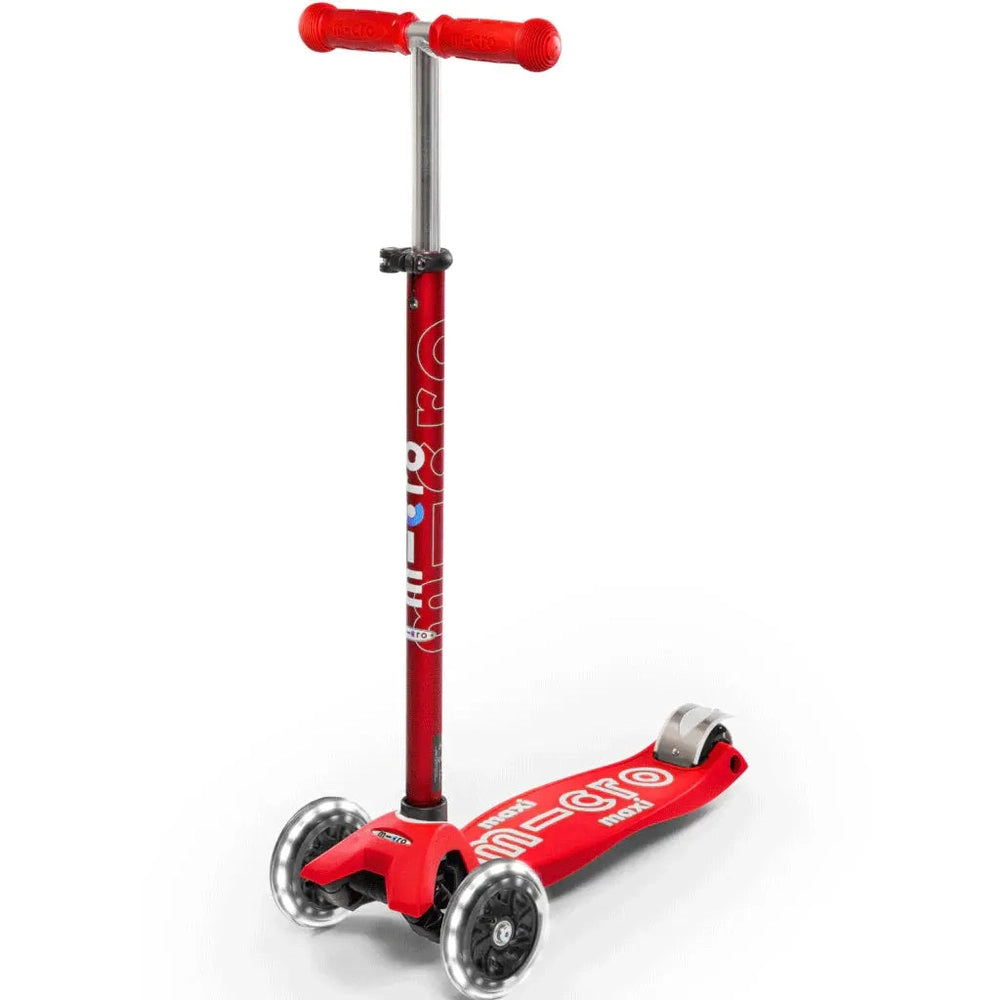 Micro Maxi Deluxe LED scooter for kids, red three-wheel design; child grips bright red handlebars and rides.