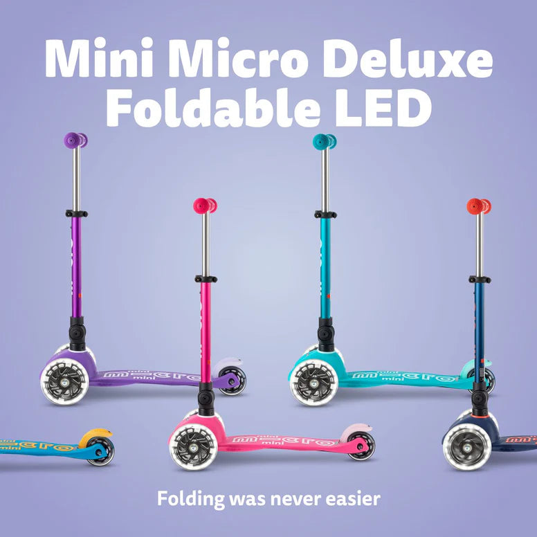 Micro Mini Deluxe Foldable LED Scooter; five colorful MICRO scooters stand upright to show foldable LED wheels.