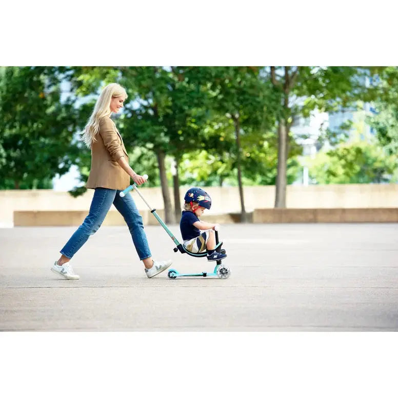 Micro Mini2Grow Deluxe LED Scooter in light blue; adult pushes a helmeted child riding outdoors.