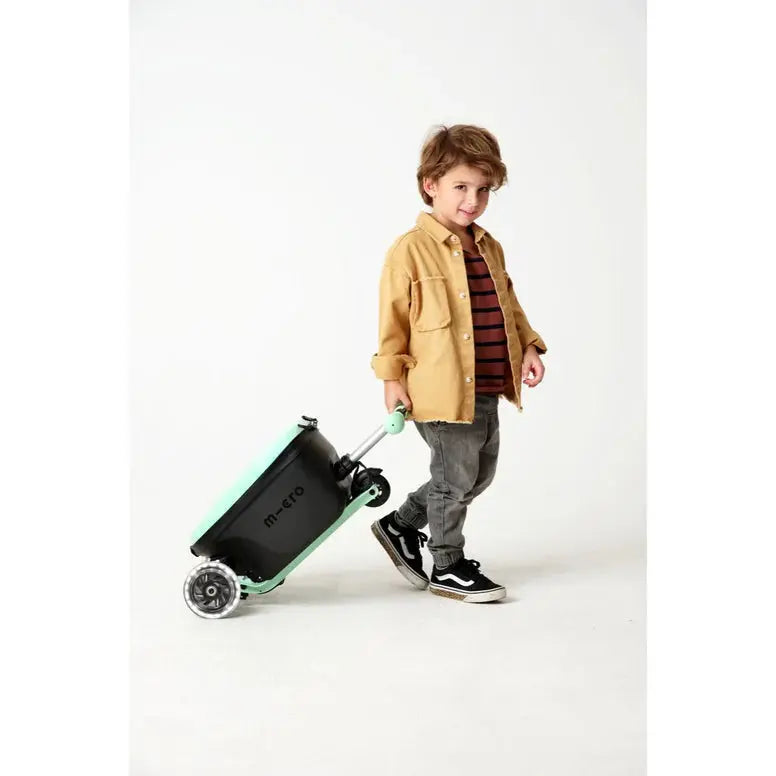 Micro Scooter Junior Luggage Mint suitcase, mint body and wheels, pulled by a young child.