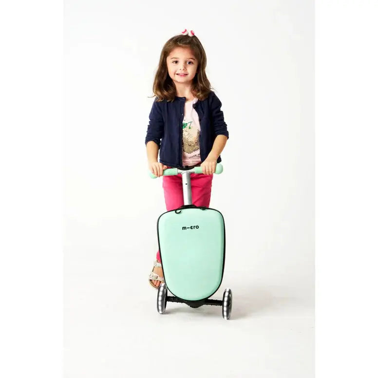 Micro Scooter Junior Luggage Mint, mint-colored scooter suitcase; a girl rides it with both hands on the handles.