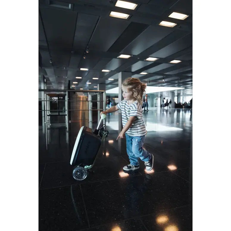 MICRO Micro Scooter Junior Luggage Mint being pushed by a child through an airport terminal.