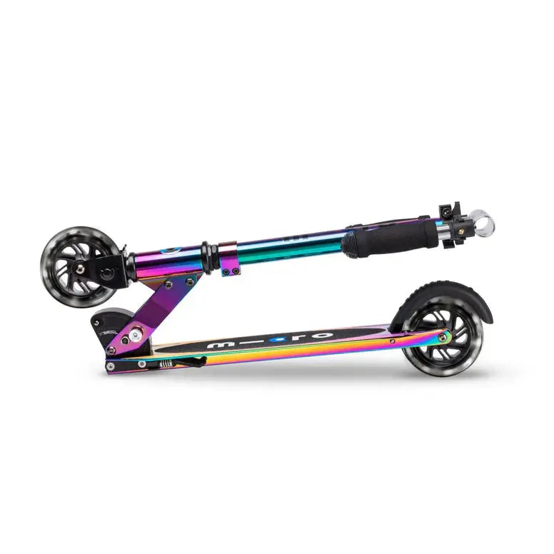 Micro Sprite LED Scooter in rainbow metallic frame with black grip, shown folded for portable carry.
