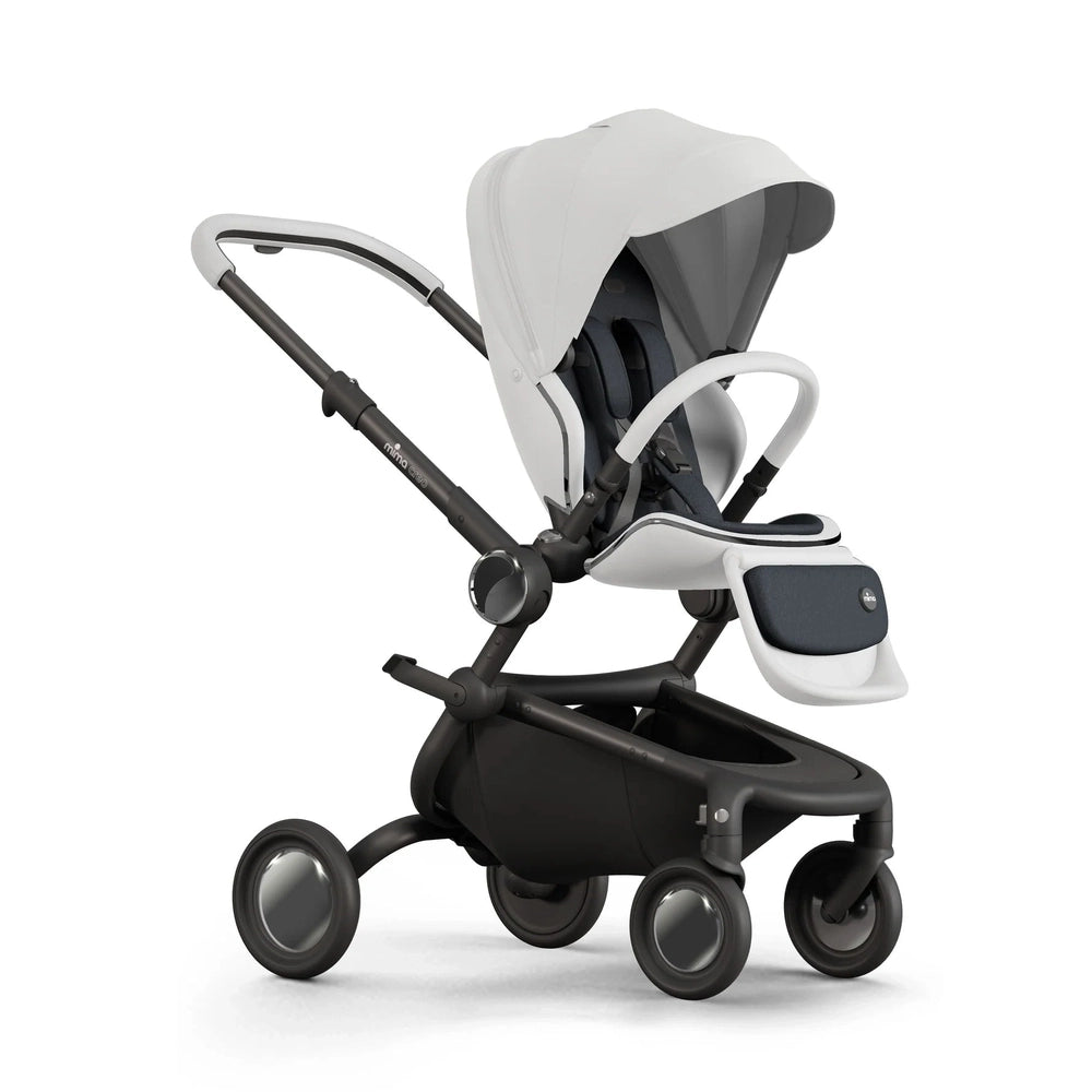 MIMA Creo stroller in white with black frame; canopy extended, adjustable seat, and front storage basket in use