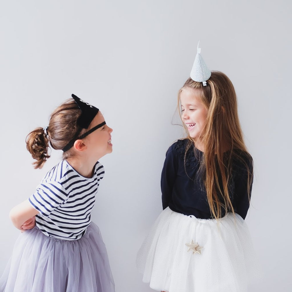 Mimi & Lula Mermaid Hat Blue on girl with navy top and white tulle skirt, smiling.