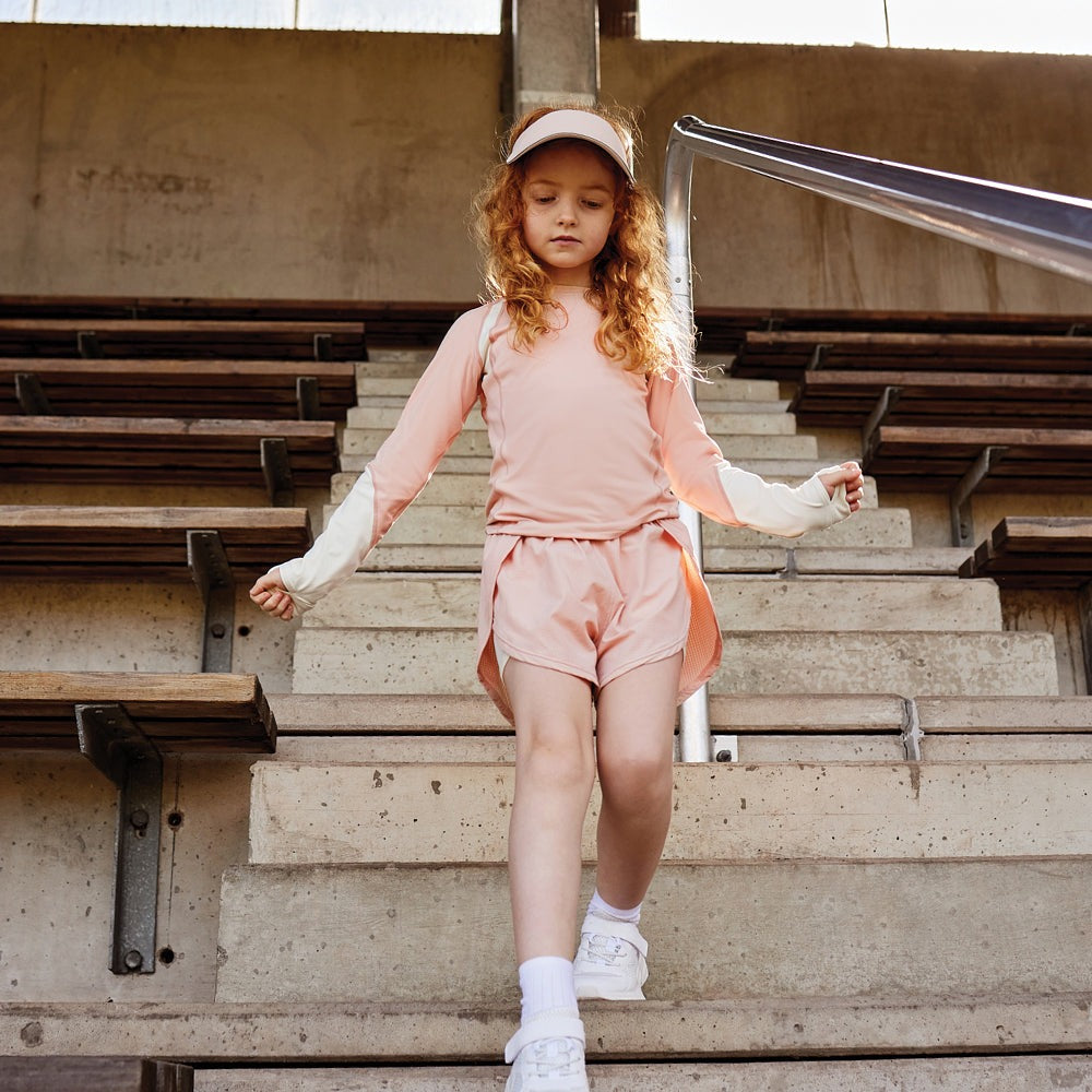 MINI A TURE Matlendi Long Sleeve Shirt Rose Dust; pink top worn by girl walking down stadium stairs.