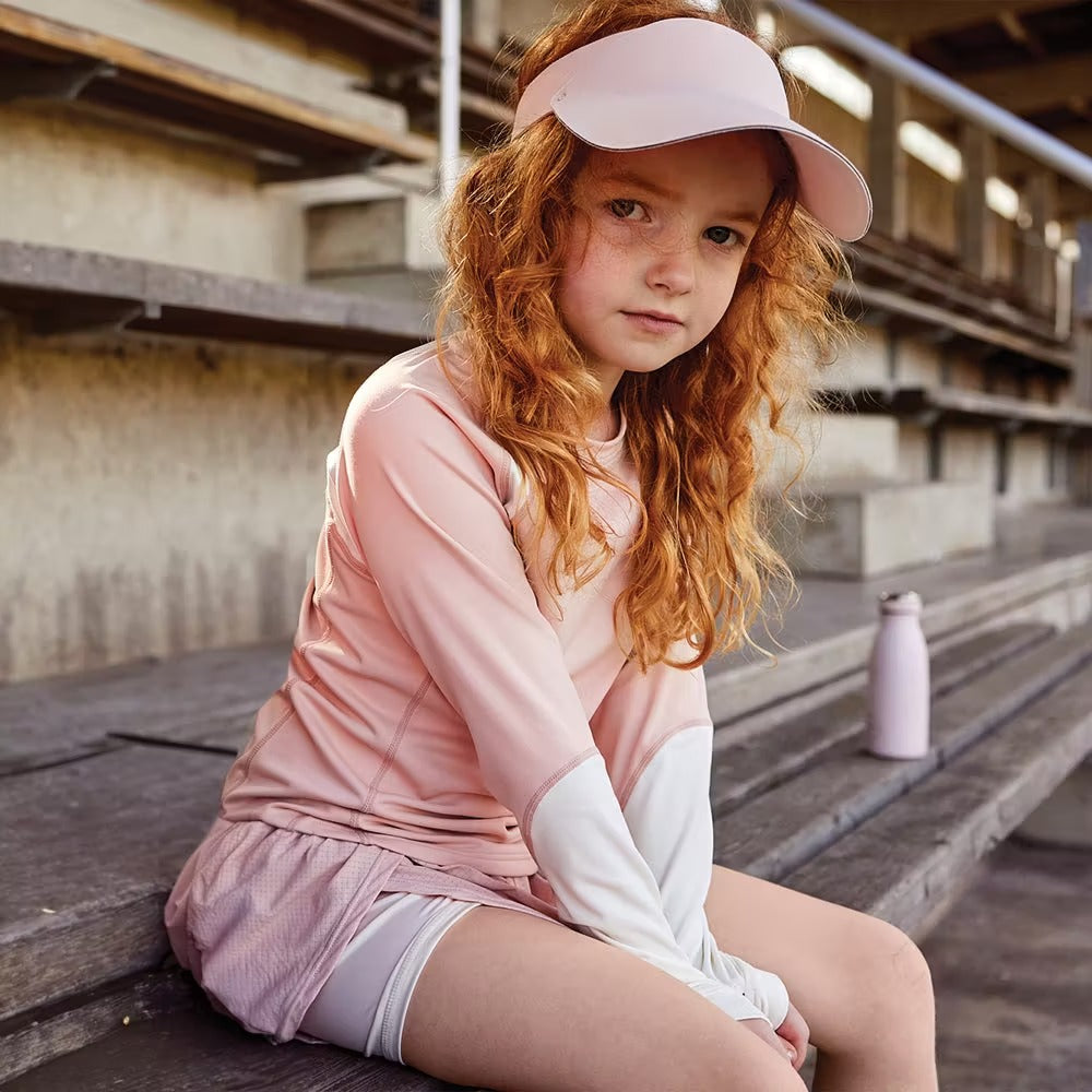 Mini A Ture Matlendi Long Sleeve Shirt Grs Rose Dust on a girl sitting calmly on wooden bleachers in soft light.