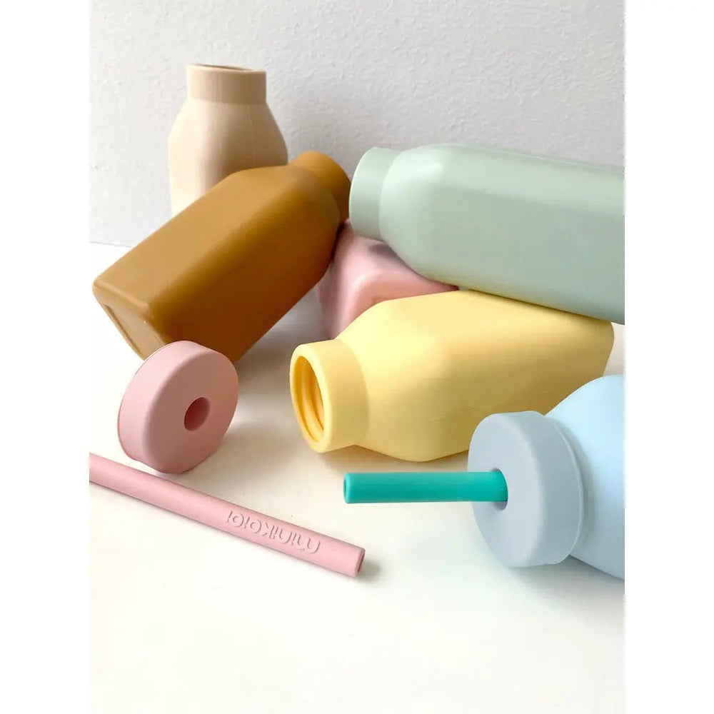 MINIKOIOI Bottle & Straw set; pastel silicone bottles with teal straw visible in the blue bottle.