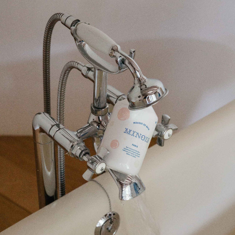 Minois Paris bath foam 500 ml bottle on chrome bathroom tub faucet