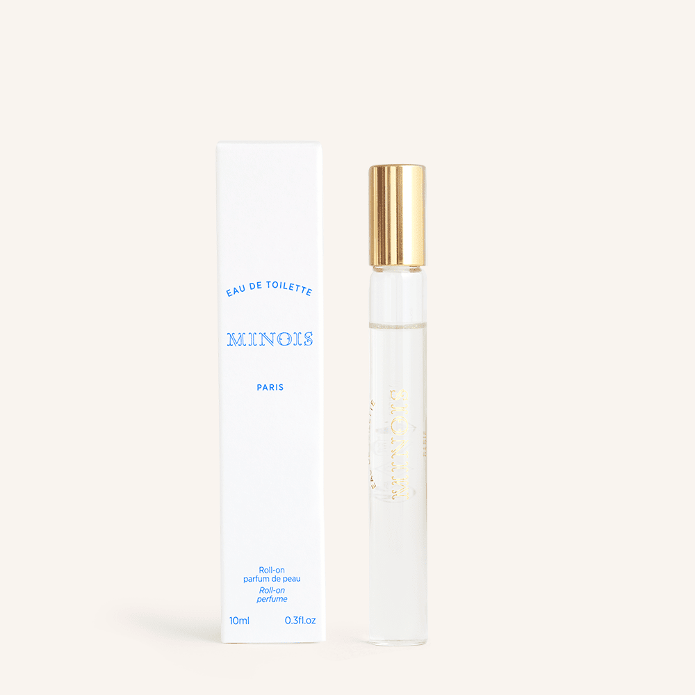 Minois Paris Eau de Toilette Roll-On, 10 ml, clear bottle with gold cap beside white box.