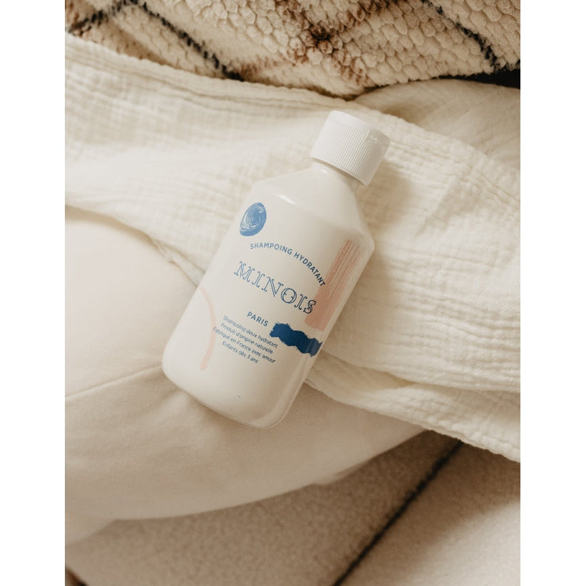 Minois Paris hydrating shampoo 300 ml white bottle with blue text on beige fabric