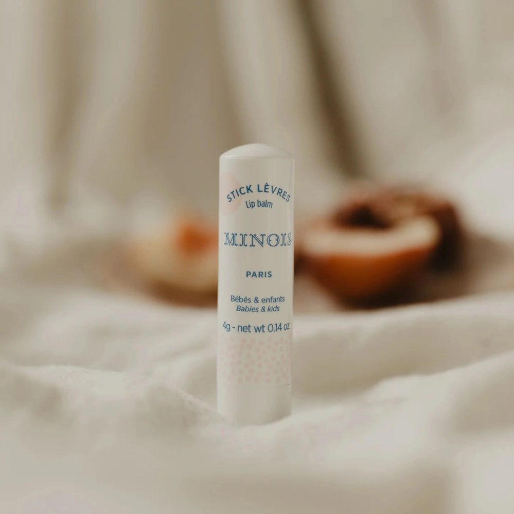 Minois Paris lip balm stick in a white tube with blue text