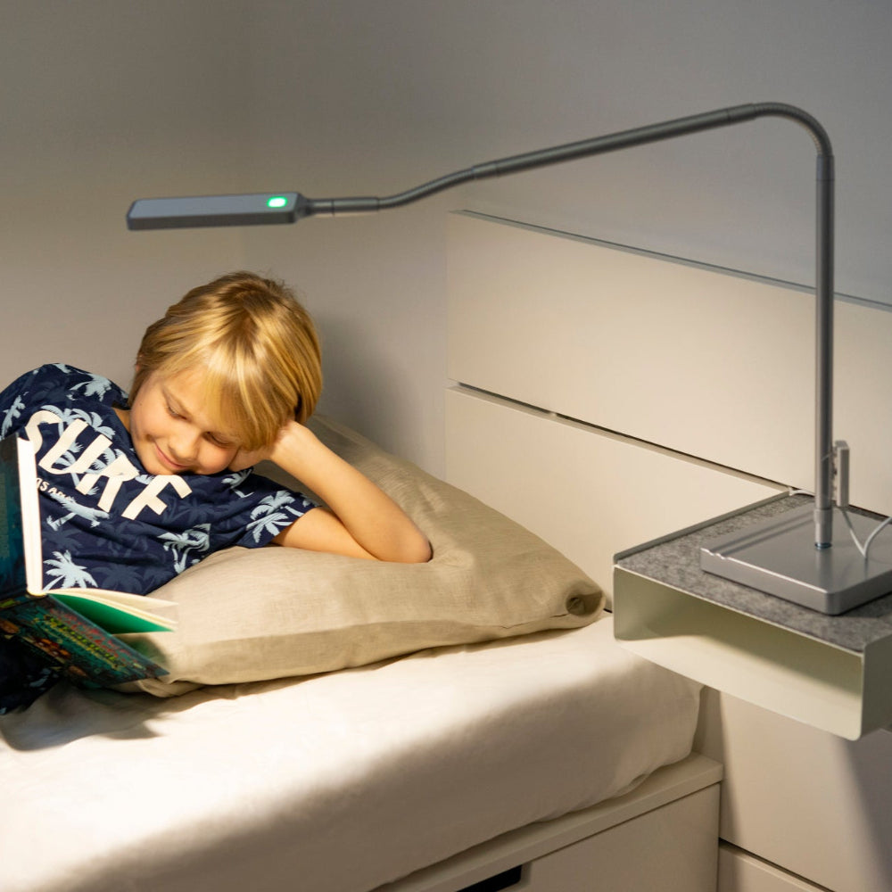 Moll L7 Designer LED Desk Lamp, gray adjustable arm, green indicator, on a bedside table