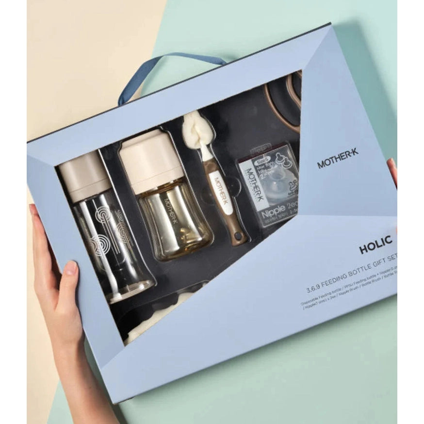 Mother-K Holic 3.6.9 feeding bottle gift set with two bottles, brush, and nipple pack in a light blue box