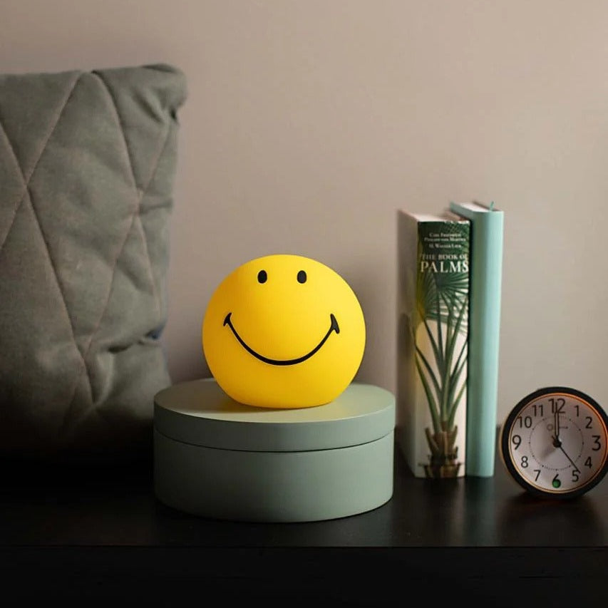 Mr Maria Bundle of Light Smiley: yellow smiley LED ball on mint green base with palm-themed book and clock nearby