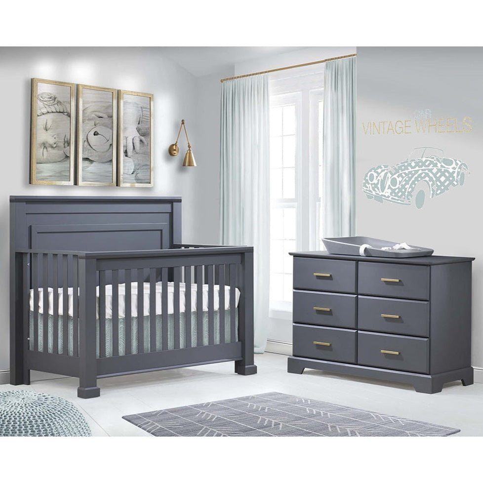 Natart Taylor 5 In 1 Convertible Crib in dark gray with a matching dresser in a modern nursery.